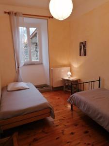 a bedroom with two beds and a window at Domaine de Salomony in Marcols-les-Eaux