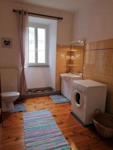 a bathroom with a washing machine and a sink at Domaine de Salomony in Marcols-les-Eaux