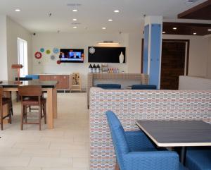 un ristorante con sedie e tavoli blu e un bancone di Holiday Inn Express Hotel and Suites Abilene, an IHG Hotel ad Abilene