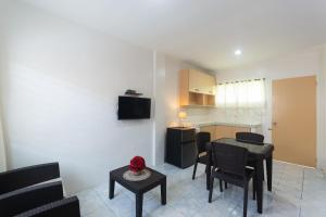 eine Küche und ein Wohnzimmer mit einem Tisch und Stühlen in der Unterkunft OYO 556 3j's And K Apartment in Cebu City