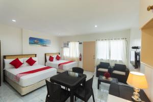 ein Hotelzimmer mit 2 Betten, einem Tisch und Stühlen in der Unterkunft OYO 556 3j's And K Apartment in Cebu City