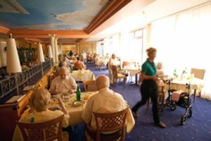 a group of people sitting at tables in a restaurant at Residenz Am Malerwinkel in Bad Sassendorf