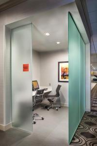 an office with a glass door and desks and chairs at Crowne Plaza Phoenix Airport, an IHG Hotel in Phoenix