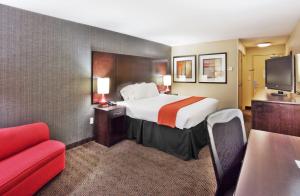 a hotel room with a bed and a red couch at Holiday Inn Express Hotel & Suites Atlanta-Cumming by IHG in Cumming +24 photos