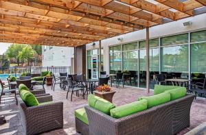 un patio con sofás, mesas y sillas en Holiday Inn Express & Suites Covington, an IHG Hotel en Covington