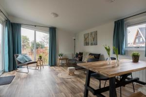 een woonkamer met een tafel en een bank bij Welcome in - Vakantiepark Fort den Haak in Vrouwenpolder