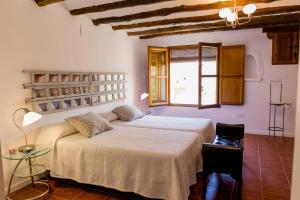 a bedroom with two beds and a window at Molino del Machero in Puebla de Don Fadrique