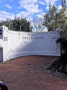 a white fence with a sign that reads the avenue at Summer Place, Southern Cross Drive, Constantia, Cape Town in Cape Town