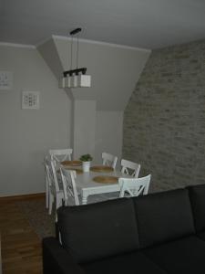 jadalnia z białym stołem i białymi krzesłami w obiekcie Apartament VIP w Zakopanem