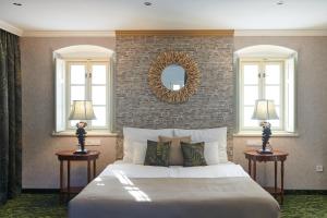 a bedroom with a large bed and two windows at Platán Udvarház - Platán Tata in Tata +47 photos