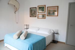 una camera bianca con un letto con una coperta blu di IseoLakeRental - Casa Stella d'Acqua a Sulzano