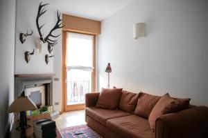 un soggiorno con divano marrone e finestra di IseoLakeRental - Casa Stella d'Acqua a Sulzano