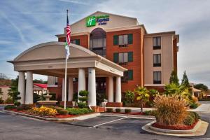マクドノーにあるHoliday Inn Express Hotel & Suites McDonough by IHGの駐車場旗付きホテルの建物