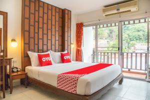 a bedroom with a large bed with red pillows at The Album Loft in Patong Beach