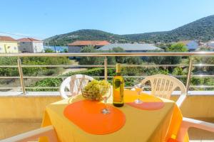 una mesa con una botella de vino y una cesta de uvas en Apartments Anton, en Vinišće