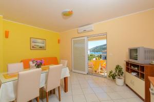 a living room with a dining table and a television at Apartments Anton in Vinišće