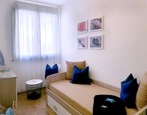 ein Schlafzimmer mit einem Bett mit blauen Kissen und einem Fenster in der Unterkunft Casa Olivastro Vista Mare in Santa Maria Navarrese