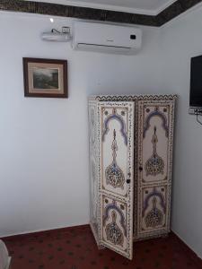 una camera con una parete bianca e un dipinto sul muro di Casa El Haouta a Chefchaouen