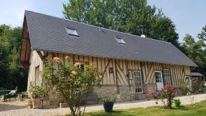 une maison en bois avec un toit en gambrel dans l'établissement Domaine Les Chillards, à Fauguernon