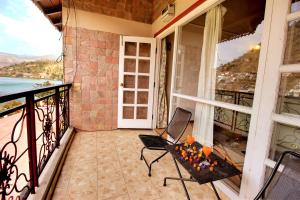 a balcony of a house with a table and chairs at Neelesh Inn- A Luxury Lake View Hotel- 20 kms from Nainital in Bhīm Tāl