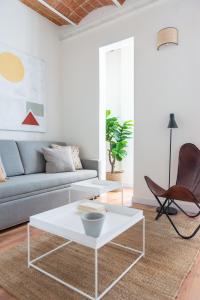 ein Wohnzimmer mit einem Sofa und einem weißen Couchtisch in der Unterkunft Diagonal Apartments by Olala Homes in Barcelona