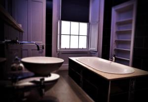 a bathroom with a tub, sink, and mirror at Culane House Hotel - B&B in Edinburgh