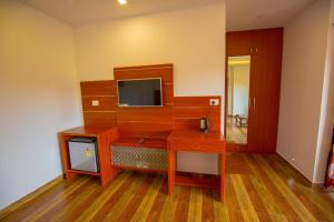 a room with a wooden desk with a tv on it at The Lake View Munnar Resort in Munnar