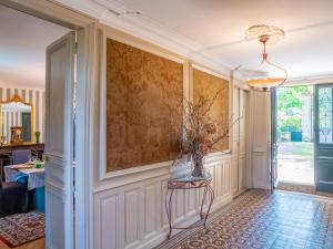 un corridoio di una casa con una sedia e un muro di Château l'Hubertière, classé du tourisme 4 étoiles a Bouresse