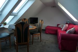 uma sala de estar com um sofá e uma mesa com cadeiras em "Haus am Deich" em Cuxhaven