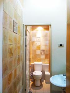 La salle de bains est pourvue de toilettes et d'un lavabo. dans l'établissement GK Gallery Rumah Sewa, à Purwokerto