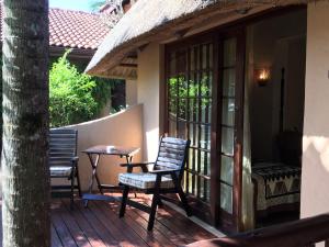 un patio con mesa y sillas en un porche en Afrikhaya Guest House, en St Lucia