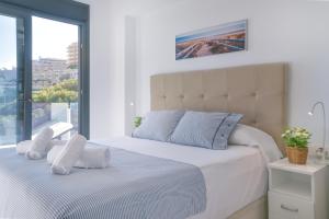 ein Schlafzimmer mit einem Bett mit weißen Laken und einem Fenster in der Unterkunft Myflats Luxury Sea Coast in Arenales del Sol + 29 Fotos