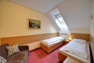 a attic room with two beds and a couch at Gościniec Nad Potokiem in Karpacz
