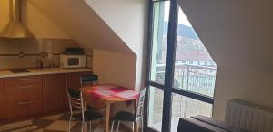 - une cuisine avec une table, des chaises et un four micro-ondes dans l'établissement Apartamenty Krynica Zdrój, à Krynica-Zdrój