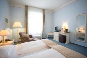 a hotel room with a bed and a living room at Trip Inn PostHotel Düren in Düren - Eifel