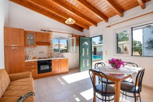 a kitchen and dining room with a table and chairs at Olympia Paxos Villas & Apartments in Gaios