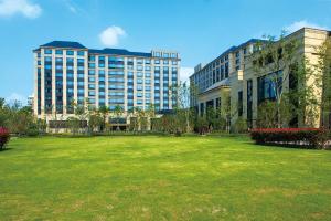 een groot grasveld voor een groot gebouw bij Crowne Plaza Shanghai Pujiang, an IHG Hotel in Shanghai