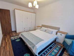 a bedroom with a large bed with a blue rug at Charming apartment in villa in Iaşi