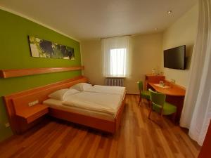 Dormitorio con cama, escritorio y TV en Hotel-Gasthof Zum Freigericht en Alzenau in Unterfranken