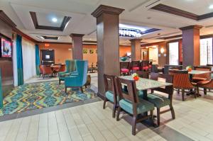 Holiday Inn Express & Suites San Antonio SE by AT&T Center, an IHG Hotel في سان انطونيو: لوبي فندق مع طاولة وكراسي