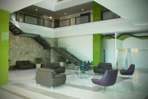 a lobby with couches and chairs and a staircase at Holiday Inn Queretaro Zona Krystal, an IHG Hotel in Querétaro
