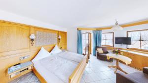 a bedroom with a large bed and a living room at Hotel Haus Seehang in Konstanz