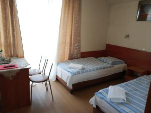 Hotel Górsko في فياليتشكا: غرفة فندقية بسريرين وطاولة وكراسي