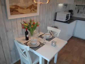 un tavolo bianco con una bottiglia di vino e fiori di Vakantiewoning Akkerrand Kamperland a Kamperland Altre 12 foto