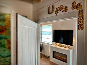 En tv och/eller ett underhållningssystem på Cottage House Weyer Horse&Groom Room