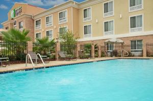 a large swimming pool in front of a house at Holiday Inn Express & Suites Alexandria, an IHG Hotel in Alexandria