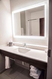 een badkamer met een wastafel en een spiegel bij Holiday Inn Express & Suites Alexandria, an IHG Hotel in Alexandria