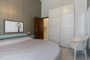 1 dormitorio con 1 cama blanca y 1 silla en Sunny Home, en Verona