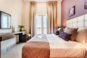 a bedroom with a large bed and a desk at Staycae Holiday Homes - Suburbia, Jebel Ali in Dubai +49 photos
