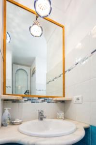 a bathroom with a sink and a mirror at L'ARCO DEI QUATTRO VENTI in Minori +26 photos